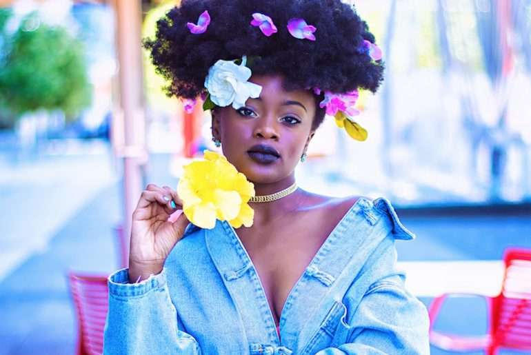 Black girl with Flowers in her hair and choker necklace and blue jean jacket