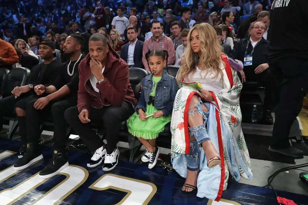 Jay z with Beyonce curtside with Blue. Blue is wearing a green dress 